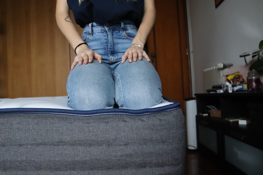 Pessoa sentada na extremidade de um colchão